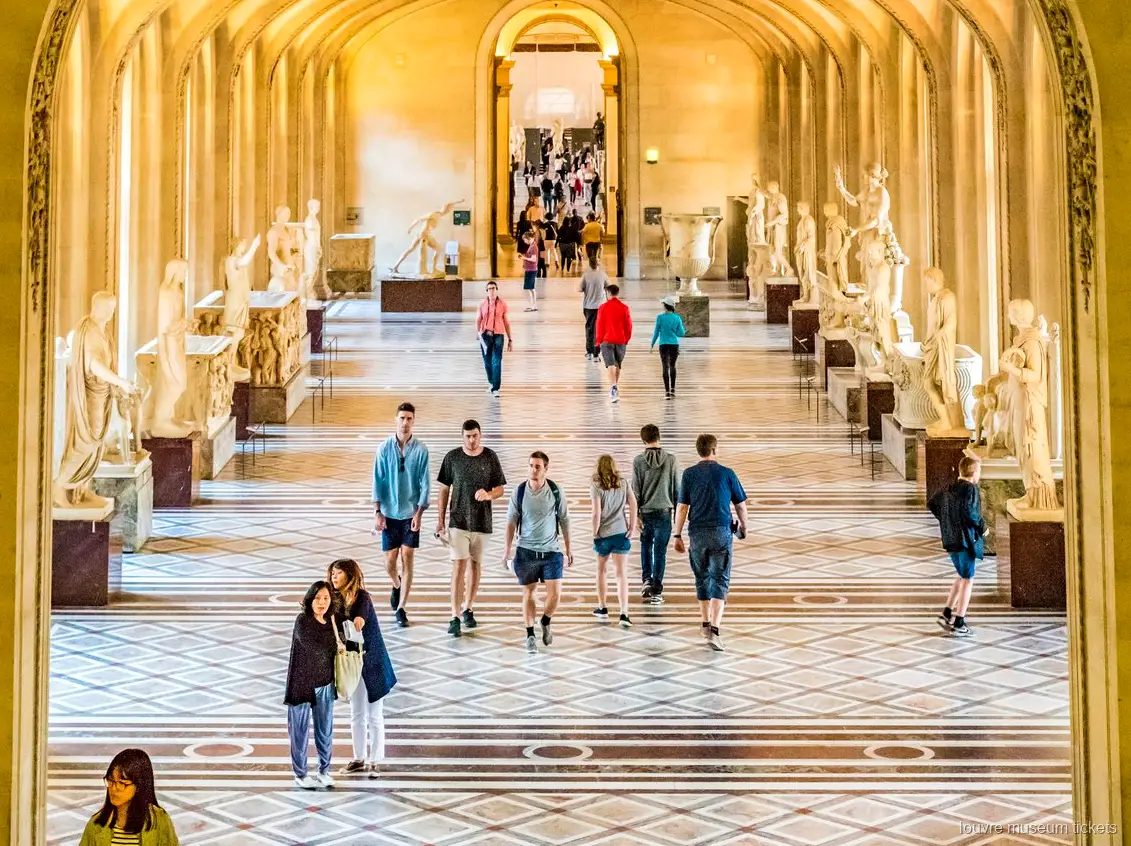 Besucher in einer Galerie antiker Skulpturen mit Bögen und Marmorboden, ein Flügel mit Louvre Tickets