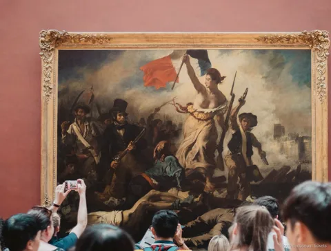 Visitors photographing Delacroix's Liberty Leading the People, one of the masterpieces seen with Louvre Museum tickets