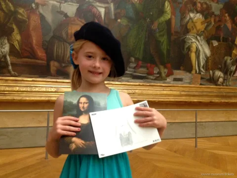 Pige med baret viser et Mona Lisa-postkort og sin tegning på en familietur med billetter til Louvre Museum