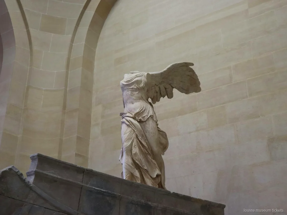 La Victòria alada de Samotràcia sobre la seva base de pedra en forma de proa, una parada amb entrades del Museu del Louvre