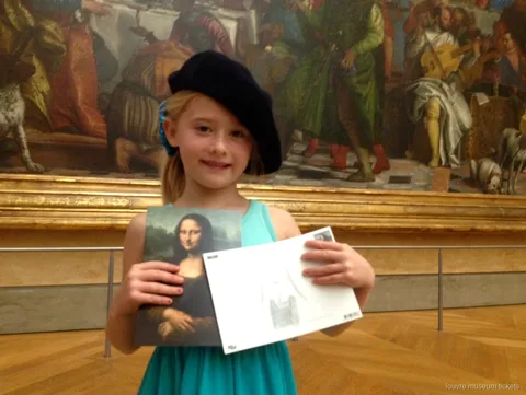Nena amb boina mostrant una postal de la Gioconda i el seu dibuix, visita familiar amb entrades al Museu del Louvre